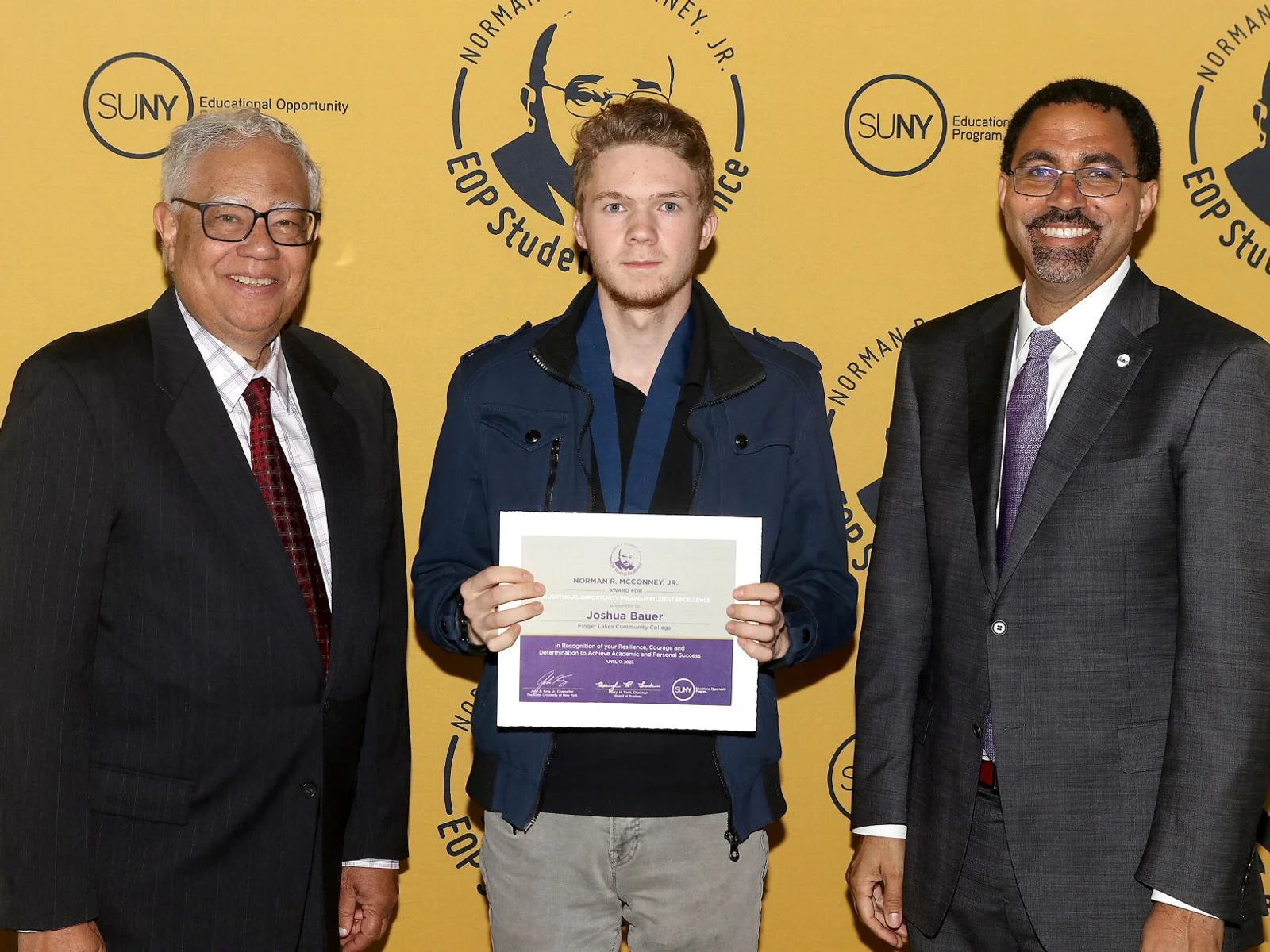 3 people, one holding certificate