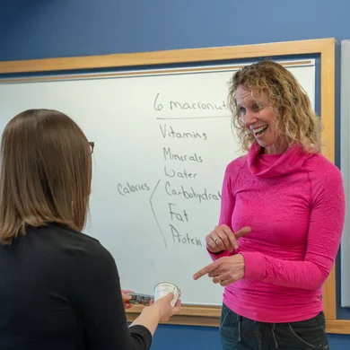 A nutrition and dietetics student talking to faculty after class.