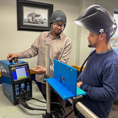 FLCC student and instructor work together with welding learning equipment.