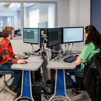 Students in computer lab using dual screen monitors.