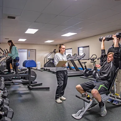 Kinesiology and Human Performance students in athletic training room evaluating a fitness routine.