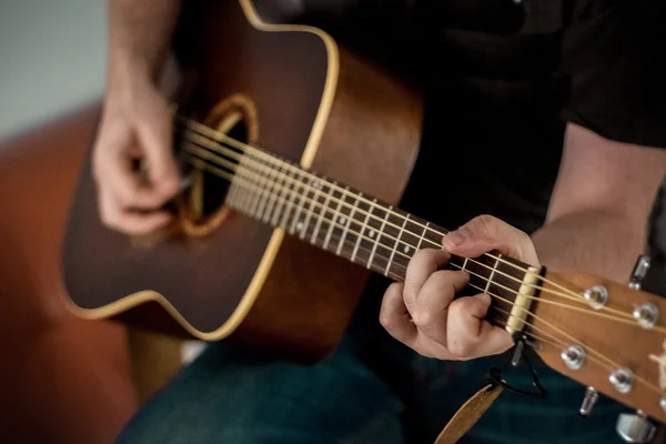 Closeup of guitar showing only hands of musician