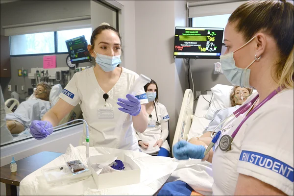 Two nursing students in uniforms in a hospital environment