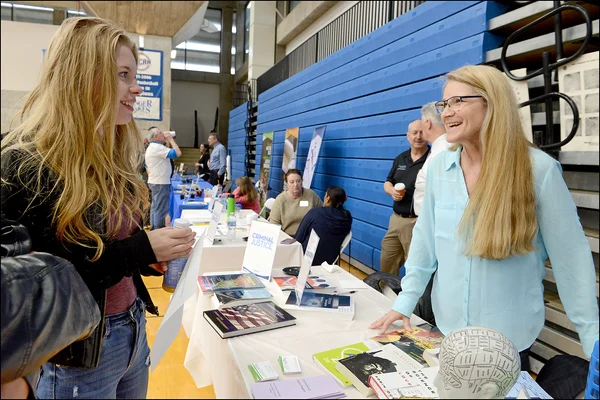 Young woman talking to female professor