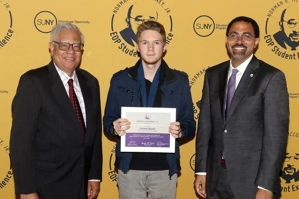 3 people, one holding certificate