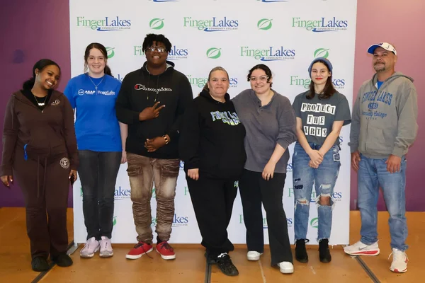 7 students posing in front of an FLCC banner