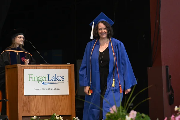 Woman in graduation cap and gown ready to walk across the stage