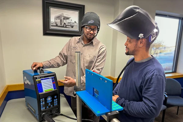 FLCC student and instructor work together with welding learning equipment.