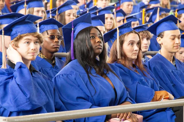 FLCC graduates in blue gowns and caps on commencement day, preparing for their future careers.