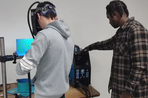 Student wearing visor engaged in simulation with instructor watching