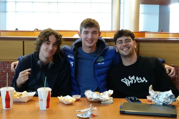 Three students sit at a table in the cafe for a Movie and Meal event