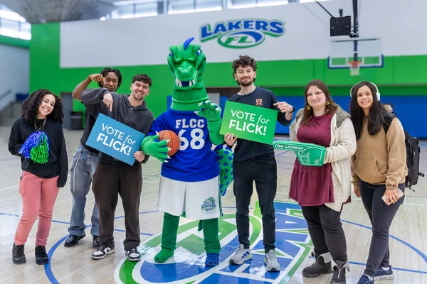 Students pose with Flick while holding “Vote for Flick” signs.