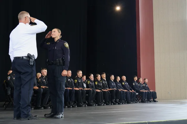 Woman officer saluting male police chief