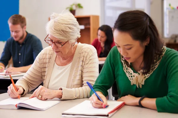 Students writing in a classroom setting.