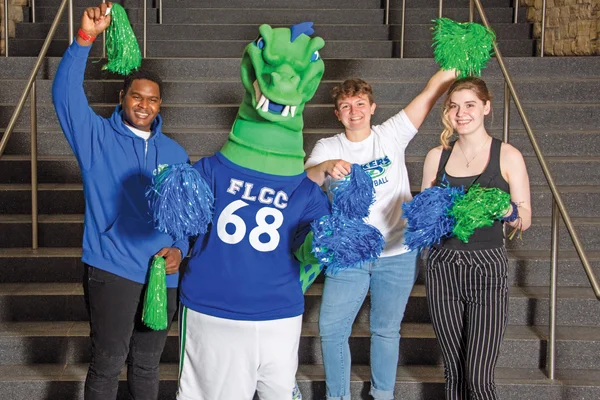 Students and the mascot Flick cheerfully welcome visitors.
