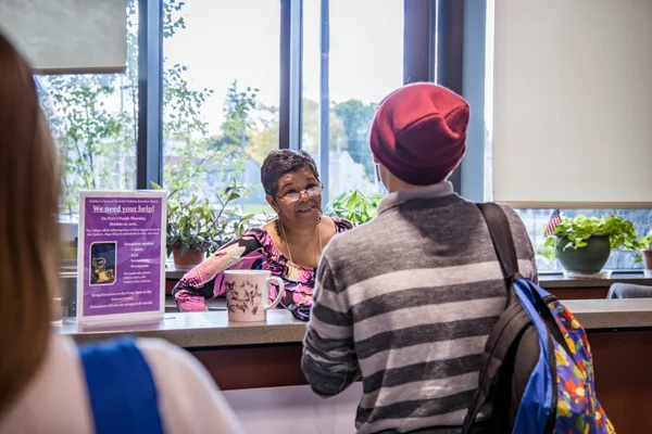 A prospective student speaking with a staff member about applying for college.