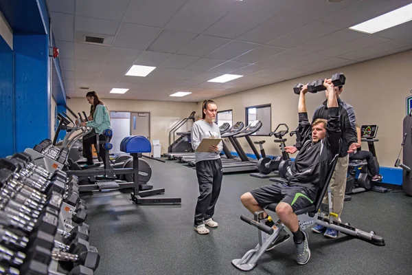 Kinesiology and Human Performance students in athletic training room evaluating a fitness routine.
