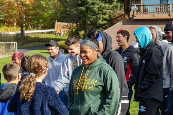 A group of educators and students learning together outside on a sunny summer day.