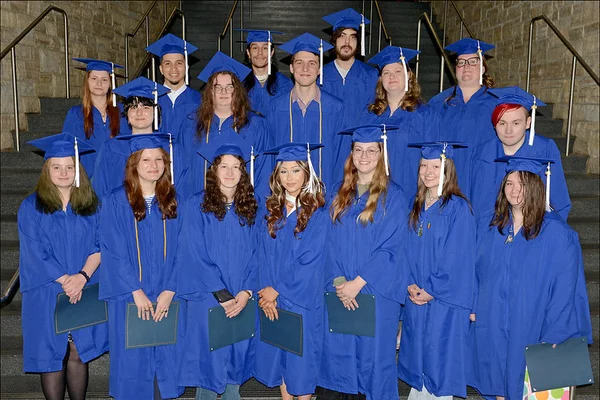 17 graduates in blue caps and gowns