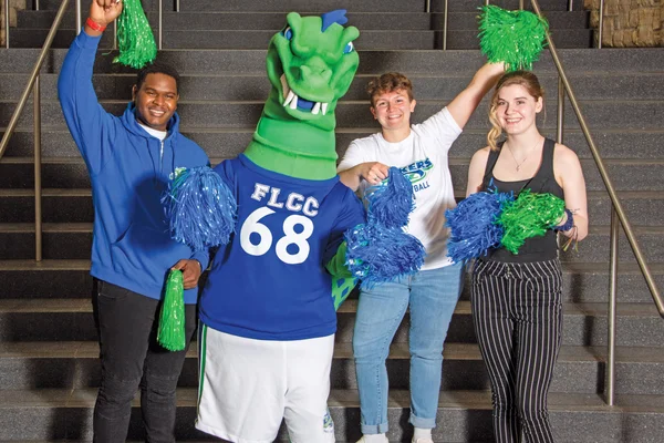 Students and the mascot Flick cheerfully welcome visitors.