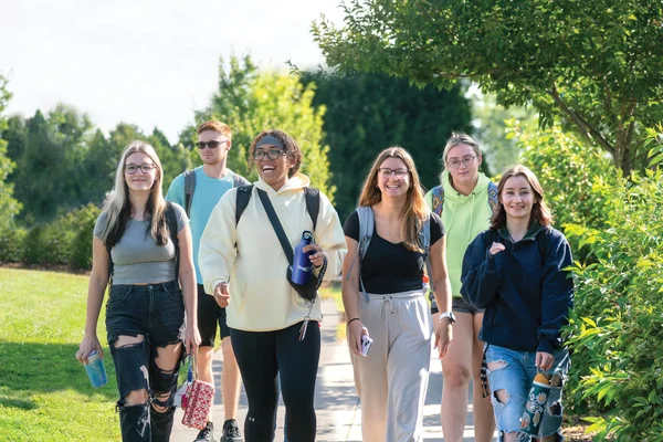FLCC students walking toward campus on a bright, summer day.