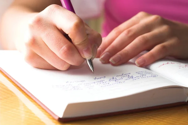 Student writing in a notebook.