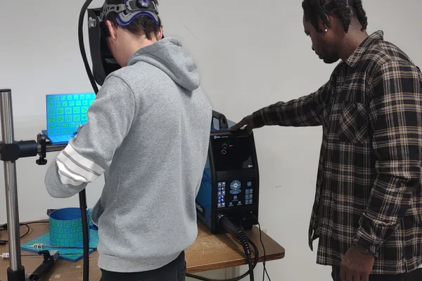 Student wearing visor engaged in simulation with instructor watching