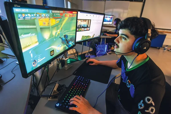 FLCC Esports athlete wearing headphones plays a round of Overwatch in a campus computer lab.