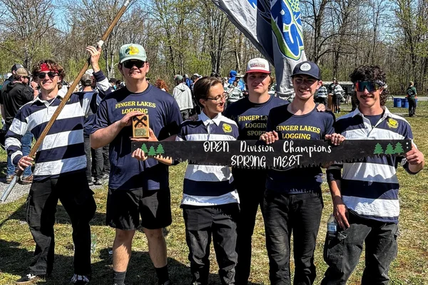 Logging sports players holding their championship prize.