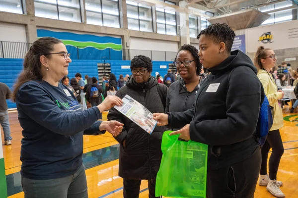 A large group of new students and their families receiving information about FLCC from college staff.