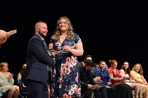 Man presenting woman with paramedic patch at ceremony