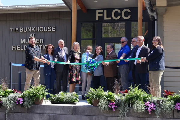 Eleven representatives gather to cut the ceremonial ribbon.