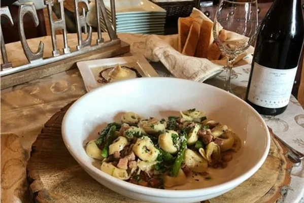 Dish of fancy pasta with wine bottle