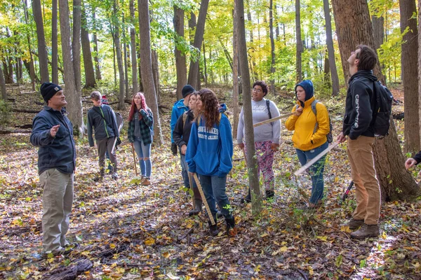 FLCC staff leads an outdoor wellness program in a forest.