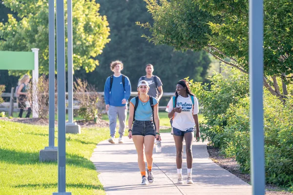 A group of FLCC students walking on campus on a bright, summer day.