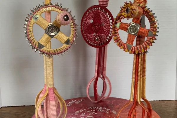 Three tall sculptures representing people