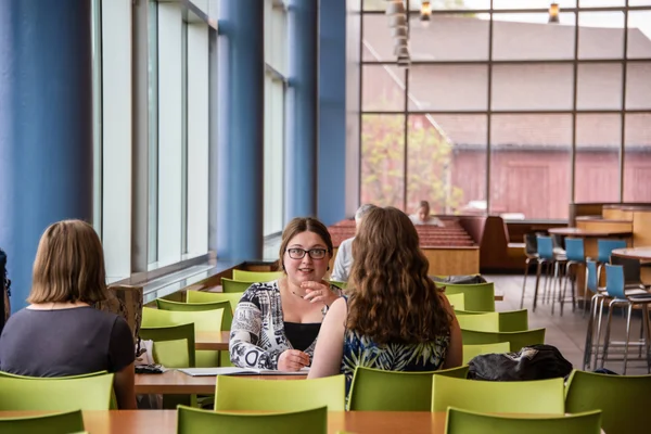 Three FLCC students sitting at a table in the Finger Lakes Cafe planning a new student opportunity.