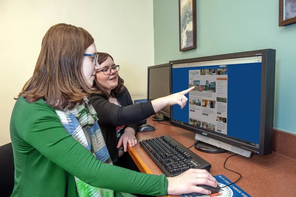 An admissions counselor helping a student request information from the FLCC website.
