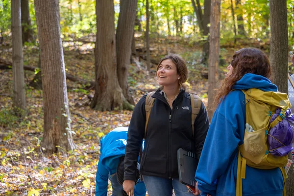 Two natural resources conservation students backpacking through a forest.