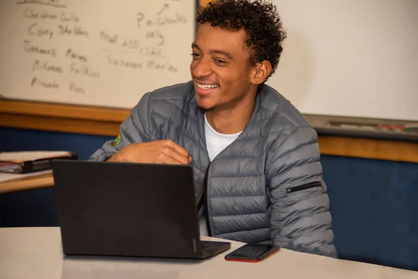 An FLCC student sitting in front of a whiteboard covered in notes.