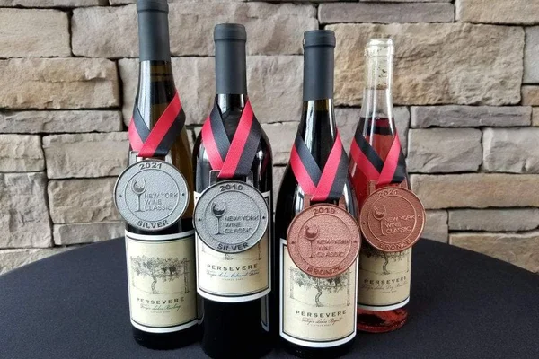 The 2020 Persevere vintage displayed with two silver and two bronze medals from the New York Wine Classic.