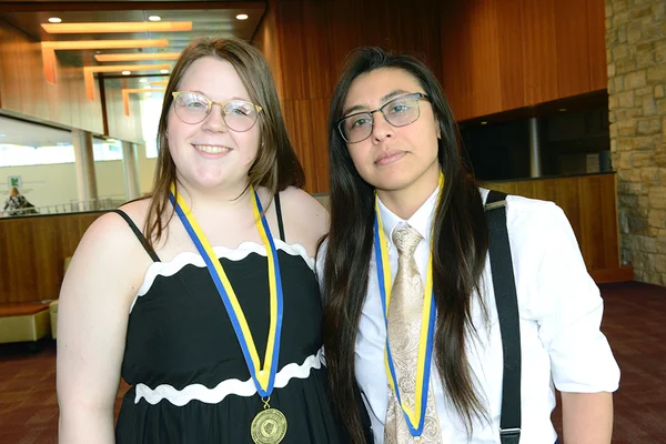 Two women posing, wearing medals