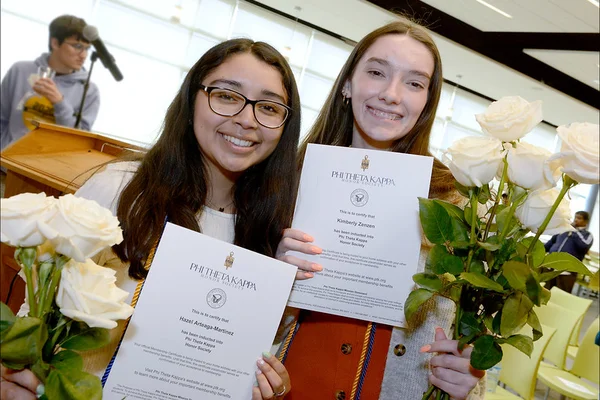 Two students pose with certificates