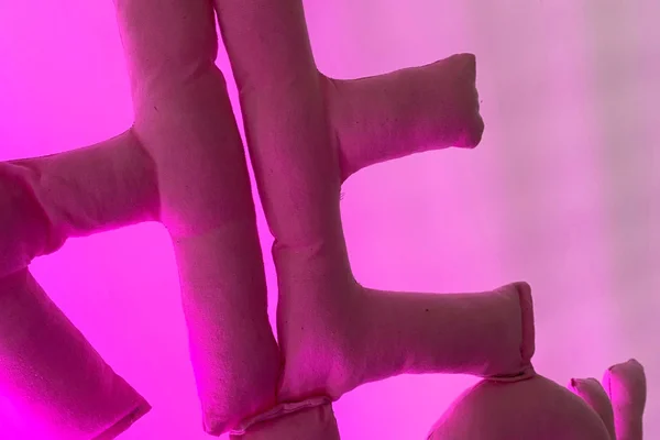 Letters made with pink fabric on light pink background