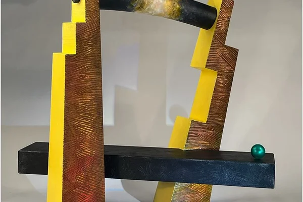 Abstract sculpture of two towers joined by plank with another plank near the bottom