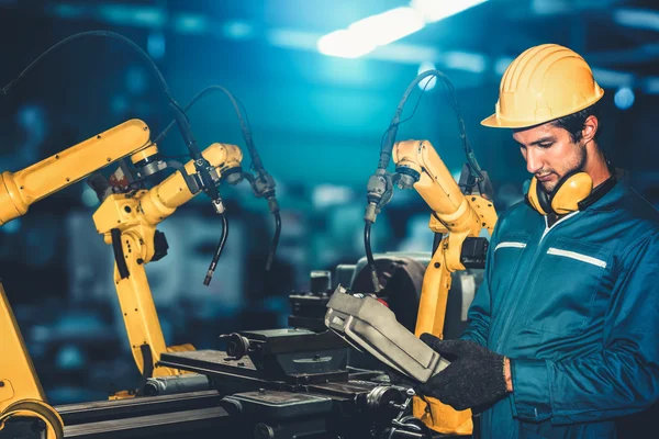An employee works with robotics in a high-tech factory.