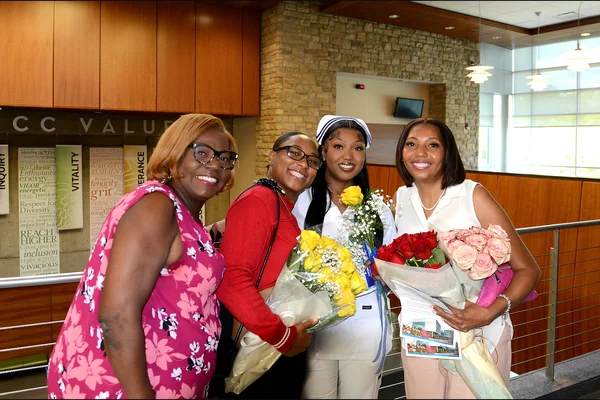 A female nursing graduate with three family members