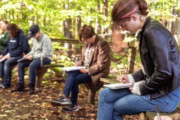 Creative Writing students work on a writing assignment in FLCC walking trails.