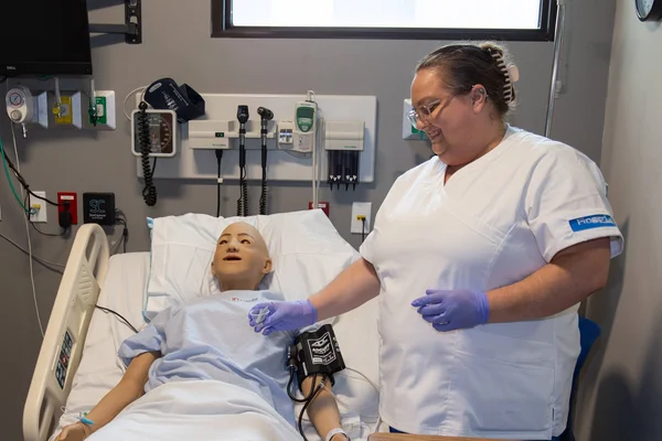 FLCC CNA student learning in a nursing simulation bay.