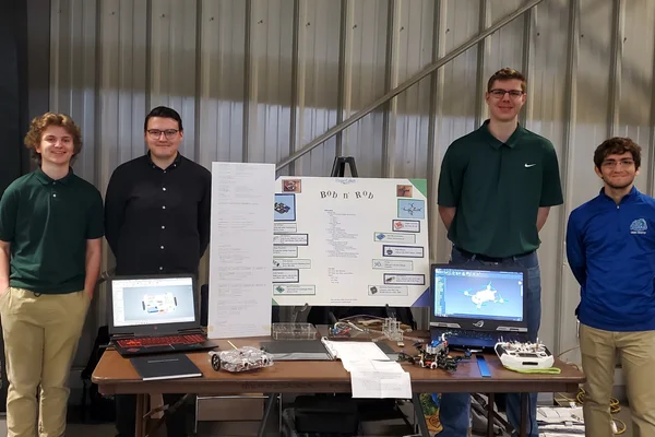 4 students posing with presentation materials